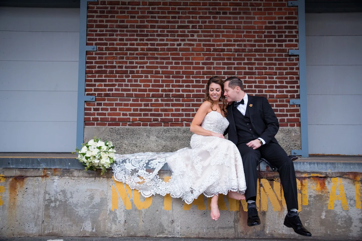 Playful editorial wedding portrait against brick architecture